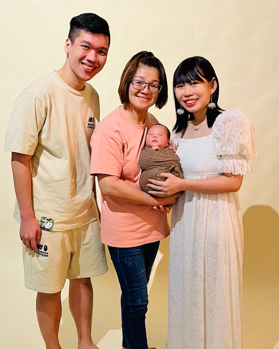 Newbubs 月嫂抱着新生宝宝，与新加坡的爸爸妈妈合照